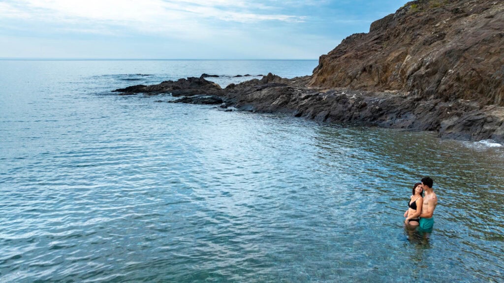 photo de drône de Chloé et Valentin partageant un moment intime dans l'eau à la plage de l'Ouille