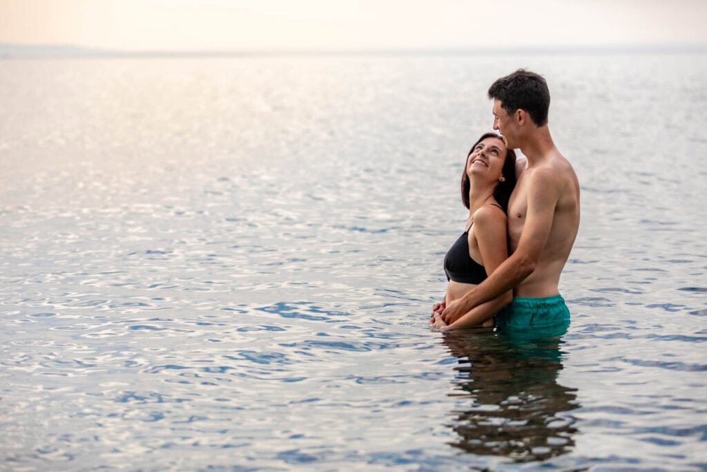 Chloé et Valentin partageant un moment intime dans l'eau à la plage de l'Ouille