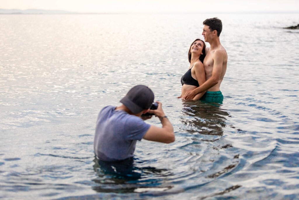 Damien Gobron en train de photographier Chloé et Valentin partageant un moment intime dans l'eau à la plage de l'Ouille