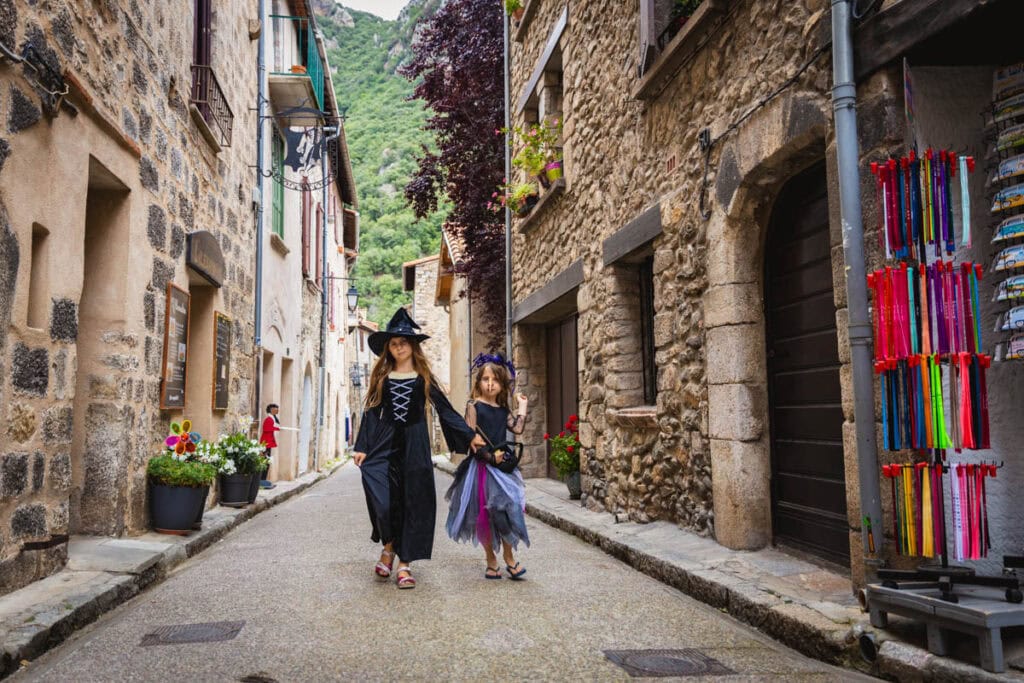 des petites sorcières marchant dans une ruelle de Villefranche-de-Conflent