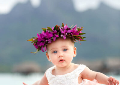 photo d'un bébé en robe avec une couronne de fleurs