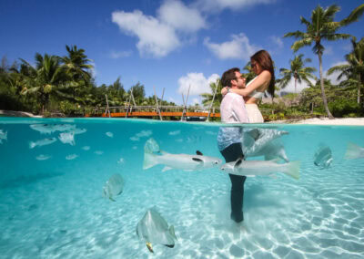 photo d'un couple dans l'eau avec des poissons