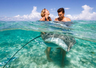 photo d'un couple dans l'eau avec une raie