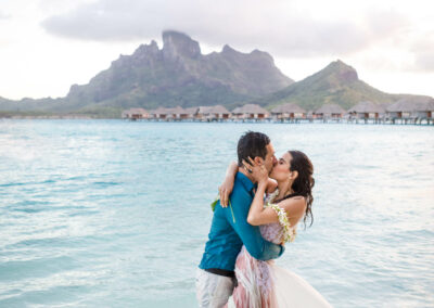 photo d'un couple de mariés mouillés dans l'eau qui s'embrassent