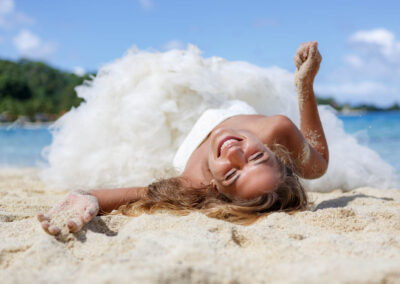 photo d'une mariée allongée dans le sable avec sa robe