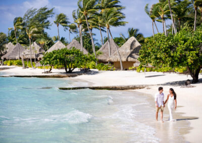 photo d'un couple marchant dans l'eau sur la plage