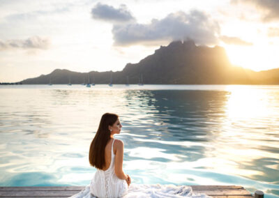 portrait d'une jeune mariée assise avec sa robe au coucher de soleil