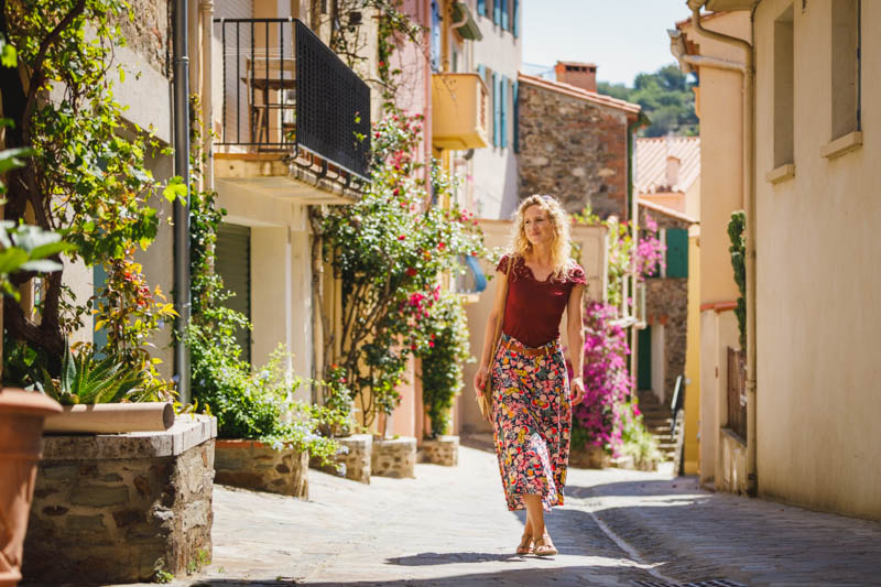 photo d'une jeune femme marchant dans les ruelles colorées de la ville de Collioure